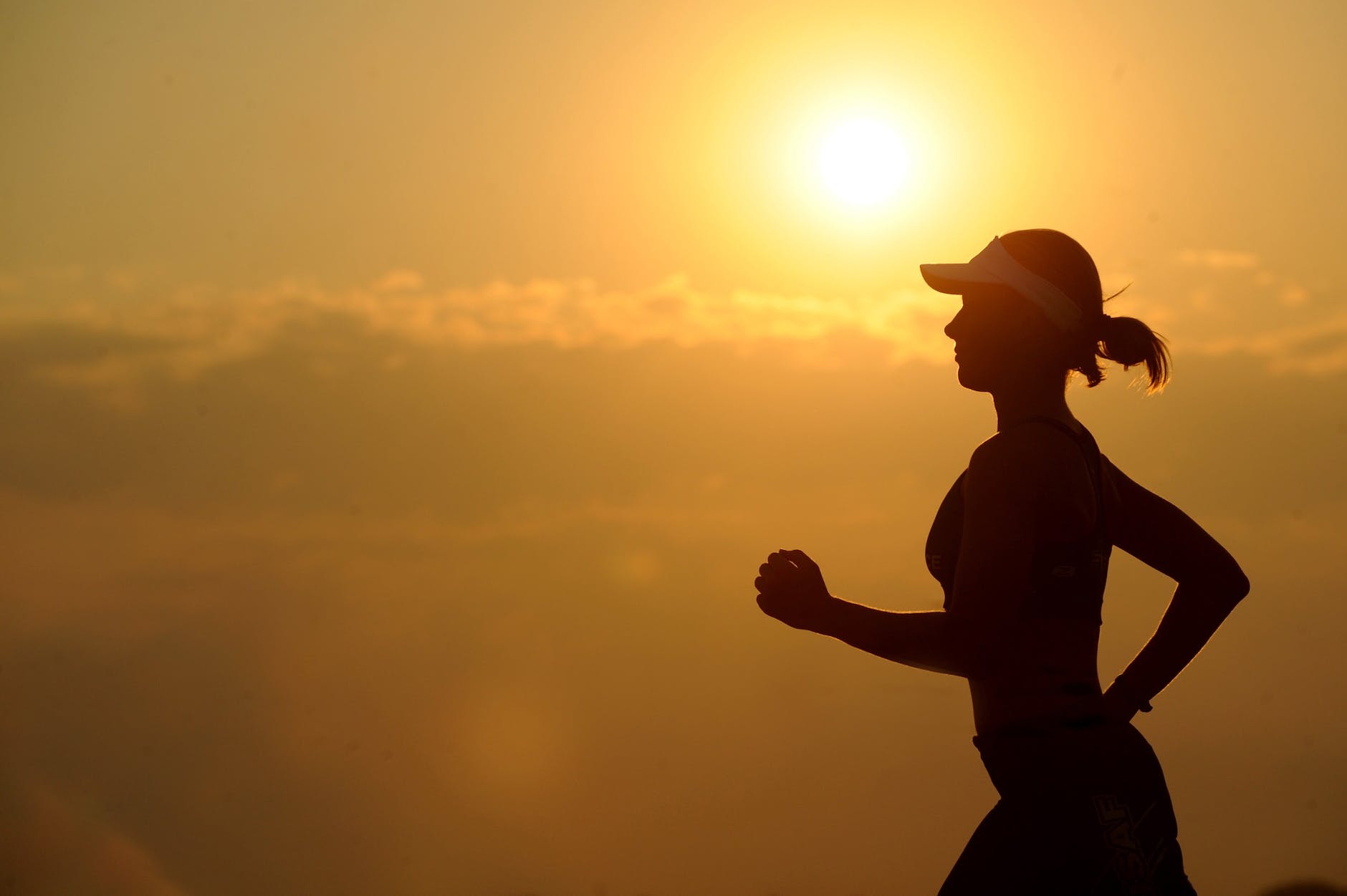 Woman runner silhouetted against a sunset
